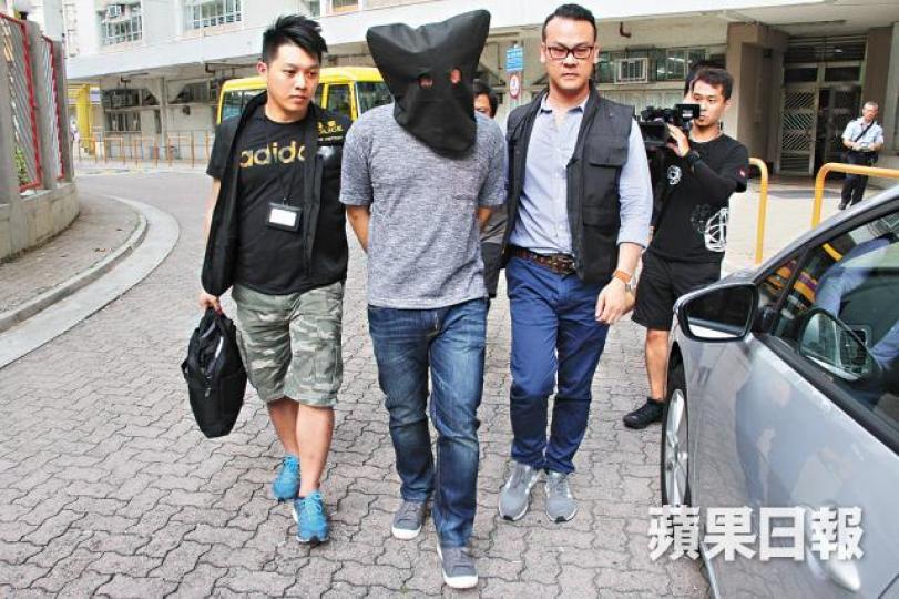 ■被捕休班警員被探員蒙頭押返警署調查。詹家志攝 ■被捕休班警員被探員蒙頭押返警署調查。詹家志攝
