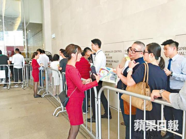 ■嘉熙售樓處外昨有女職員向睇樓客大派飲品。何耀勤攝 ■嘉熙售樓處外昨有女職員向睇樓客大派飲品。何耀勤攝