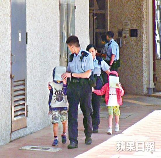 ■小兄妹由警員帶上警車期間表現乖巧,還自行用書本遮面。張培生攝 ■小兄妹由警員帶上警車期間表現乖巧,還自行用書本遮面。張培生攝