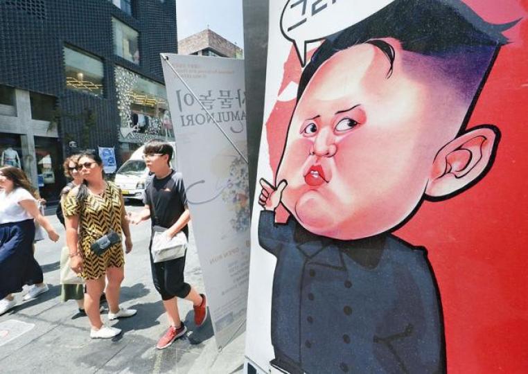 ■首爾有人掛起畫有金正恩肖像的直幅。 美聯社 ■首爾有人掛起畫有金正恩肖像的直幅。 美聯社