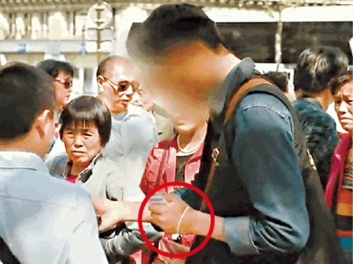 ■法媒拍到中國導遊向遊客派發重複使用的門票(圓圈示)。 ■法媒拍到中國導遊向遊客派發重複使用的門票(圓圈示)。