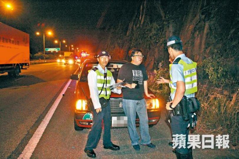 ■的士司機向警員講述意外經過。 ■的士司機向警員講述意外經過。