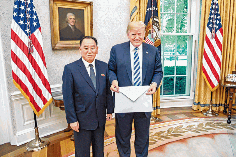 ■由金英哲（左）手中接過「大信封」的特朗普笑容燦爛而詭異。