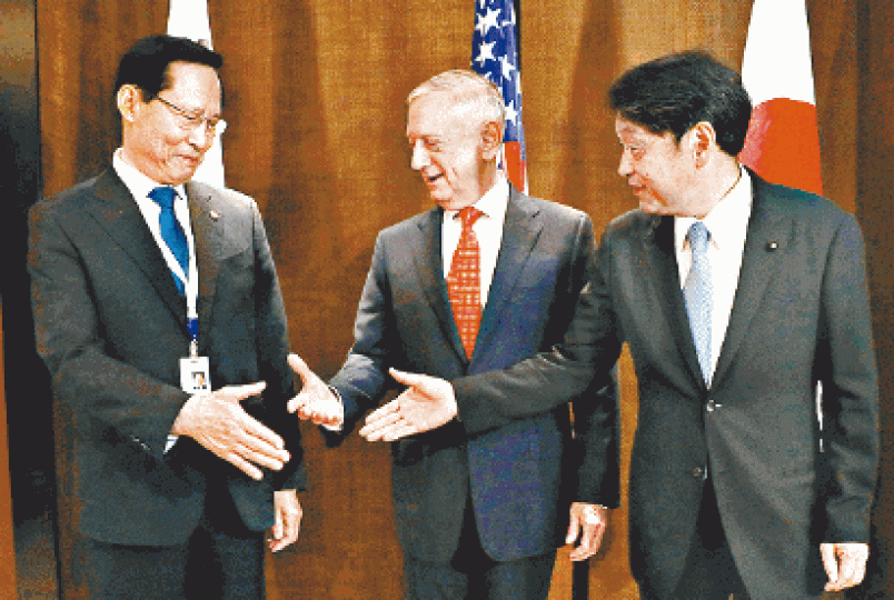 ■日美韓防長(左起)小野寺五典、馬蒂斯和宋永武昨握手。 ■日美韓防長(左起)小野寺五典、馬蒂斯和宋永武昨握手。
