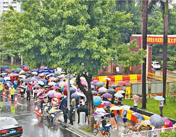■大批家長在考場門口冒雨等考生。■深圳考場外有母女相擁祝福。 ■大批家長在考場門口冒雨等考生。■深圳考場外有母女相擁祝福。