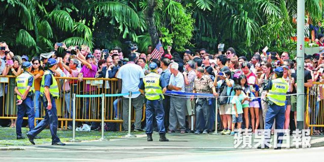 ■特朗普到新加坡總統府,場外有不少遊客及市民圍觀,有人舉起美國旗被保安制止。朱永倫攝 ■特朗普到新加坡總統府,場外有不少遊客及市民圍觀,有人舉起美國旗被保安制止。朱永倫攝