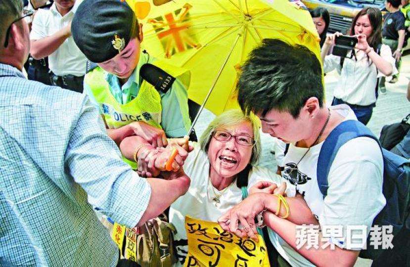 ■一直支持各被告的王婆婆因坐在囚車通道被警員帶走。許頌明攝 ■一直支持各被告的王婆婆因坐在囚車通道被警員帶走。許頌明攝