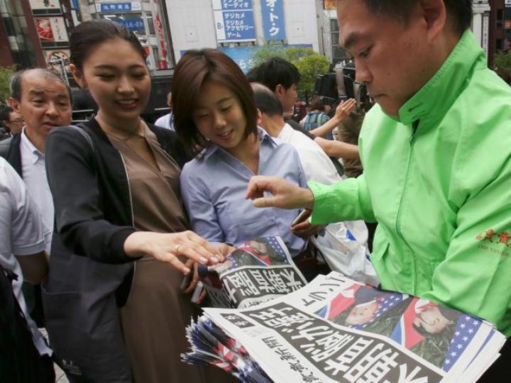 ■日本民眾爭相拿取刊有特金會最新消息的報章號外。美聯社 ■日本民眾爭相拿取刊有特金會最新消息的報章號外。美聯社