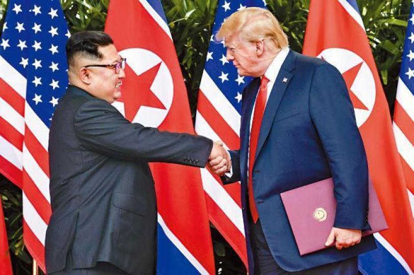 【歷史會面世紀握手】■美國總統特朗普多次與北韓領袖金正恩握手搭背,表現主動,金正恩看來笑得有點尷尬。美聯社 【歷史會面世紀握手】■美國總統特朗普多次與北韓領袖金正恩握手搭背,表現主動,金正恩看來笑得有點尷尬。美聯社