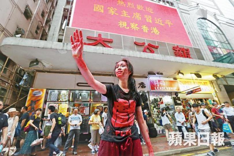 ■去年7.1遊行,有示威者在《大公報》門外表演舞蹈,寓意民心淌血。 ■去年7.1遊行,有示威者在《大公報》門外表演舞蹈,寓意民心淌血。