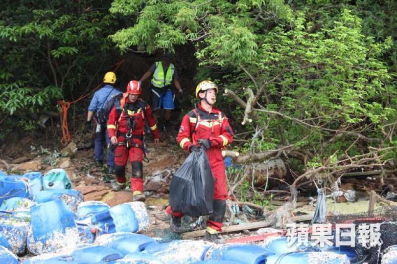 ■消防員從叢林中撿走飛機殘胲。周鴻熙攝 ■消防員從叢林中撿走飛機殘胲。周鴻熙攝