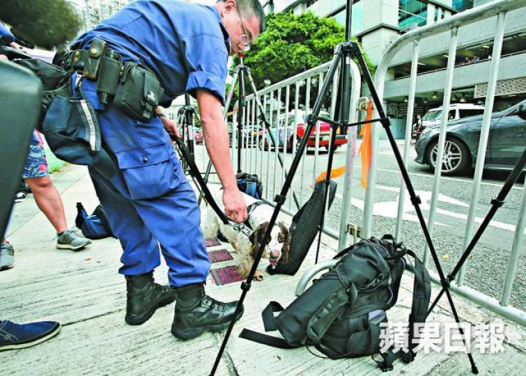 ■警方對文子星出庭嚴陣以待,派警犬檢查記者器材及背囊。黃耀興攝
■警方對文子星出庭嚴陣以待,派警犬檢查記者器材及背囊。黃耀興攝
