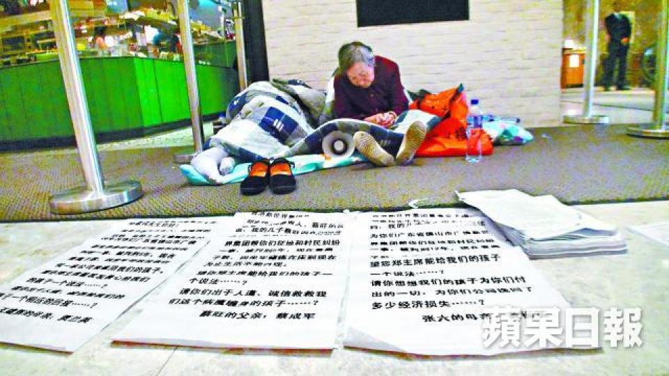 ■有內地人在新世界大廈打地鋪,並在地上擺放疑似內地法院的判罪書。 ■有內地人在新世界大廈打地鋪,並在地上擺放疑似內地法院的判罪書。