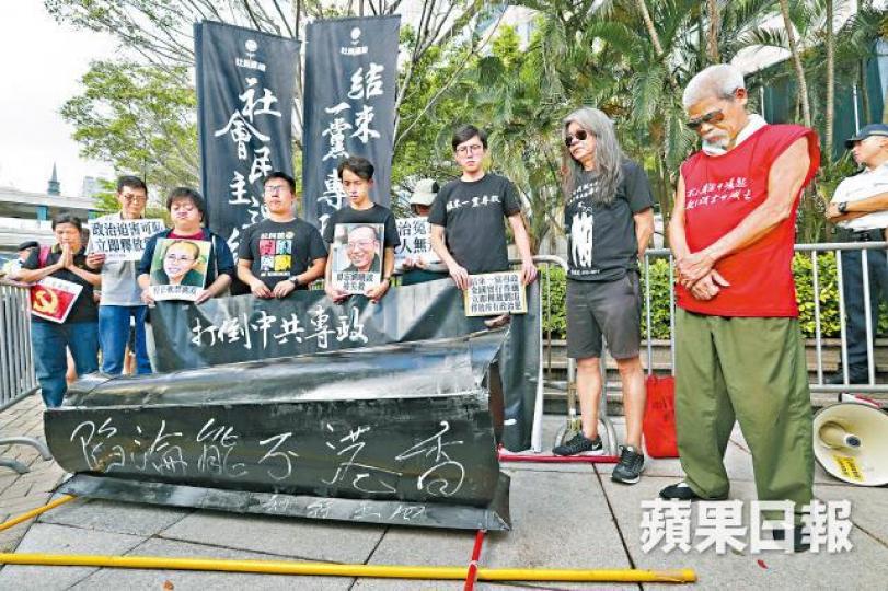 ■社民連成員昨在升旗禮現場外為民運人士默哀。 ■社民連成員昨在升旗禮現場外為民運人士默哀。