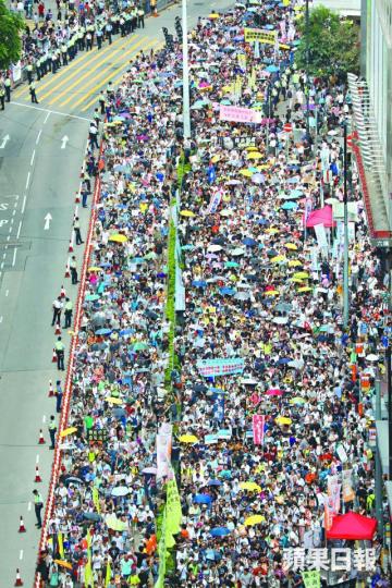 ■雖然有警員在銅鑼灣崇光百貨一帶戒備,圖阻止市民加入遊行,但仍無阻市民中途插隊。李家皓攝 ■雖然有警員在銅鑼灣崇光百貨一帶戒備,圖阻止市民加入遊行,但仍無阻市民中途插隊。李家皓攝