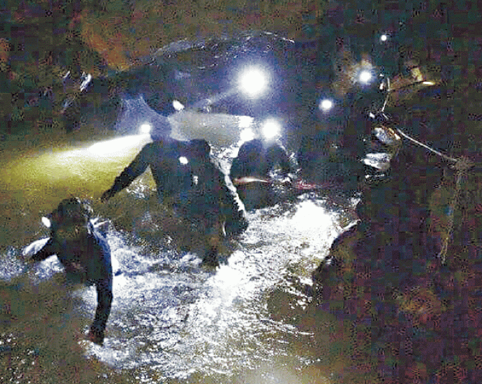 ■救援人員到洞穴內搜救,現場積水混雜泥濘,寸步難行。美聯社 ■救援人員到洞穴內搜救,現場積水混雜泥濘,寸步難行。美聯社