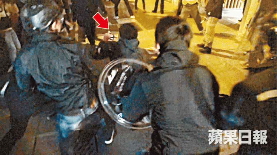■記者遭警員毆打時,一度舉起記者證(箭嘴示)表明身份。 ■記者遭警員毆打時,一度舉起記者證(箭嘴示)表明身份。