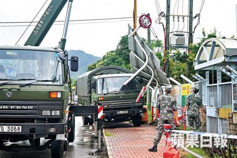 ■解放軍自行召來吊臂車,將損毀的巴士站上蓋卸下及清理現場。張家豪攝 ■解放軍自行召來吊臂車,將損毀的巴士站上蓋卸下及清理現場。張家豪攝