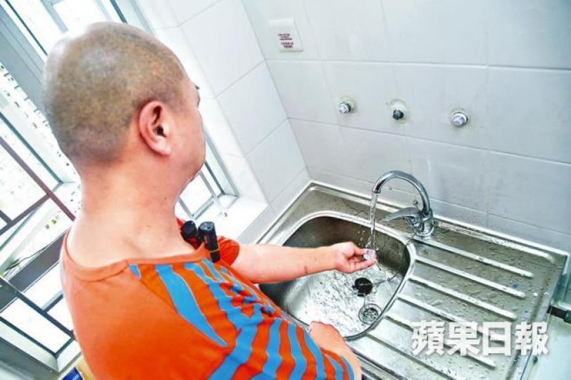 ■葵翠邨新住戶黃先生指單位水質含黑色沙粒物質。周智堅攝 ■葵翠邨新住戶黃先生指單位水質含黑色沙粒物質。周智堅攝