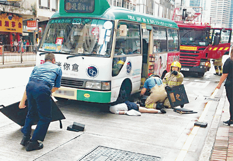 ■女生被小巴撞倒並捲入車底,消防員到場後將小巴升起救人。讀者提供圖片■肇事司機被帶上警車接受調查。簡明恩攝 ■女生被小巴撞倒並捲入車底,消防員到場後將小巴升起救人。讀者提供圖片■肇事司機被帶上警車接受調查。簡明恩攝