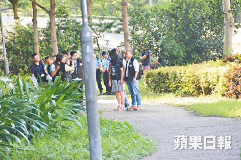 ■疑犯昨午被探員押返現場重組案情。 ■疑犯昨午被探員押返現場重組案情。