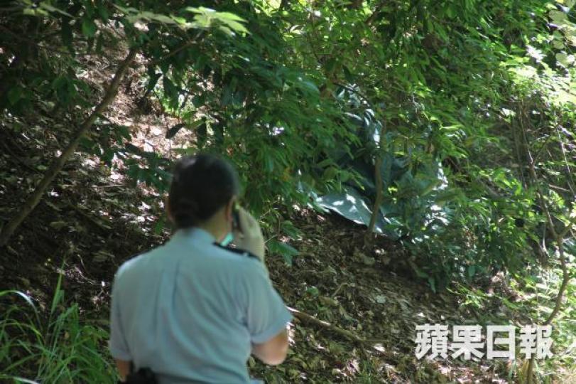 ■女子倒斃山坡,警員在場調查。劉永明攝 ■女子倒斃山坡,警員在場調查。劉永明攝