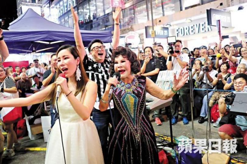 ■黃夏蕙與艾美琦合唱,引來一片歡呼聲。■湊熱鬧市民爬上竹棚向表演者揮手。 ■黃夏蕙與艾美琦合唱,引來一片歡呼聲。■湊熱鬧市民爬上竹棚向表演者揮手。