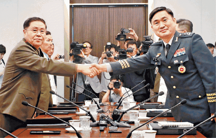 ■北韓代表安益山(左)跟南韓代表金度均(右)會談前先握手。路透社■安益山步行越過板門店兩韓分界線,進入南韓國境。美聯社 ■北韓代表安益山(左)跟南韓代表金度均(右)會談前先握手。路透社■安益山步行越過板門店兩韓分界線,進入南韓國境。美聯社