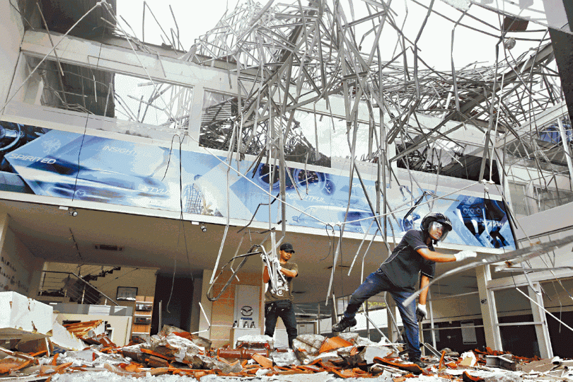 ■地震後一日，工人出動清理一幢建築物的瓦礫。　美聯社■北龍目島的醫院外擺放了地震死者遺體。　路透社