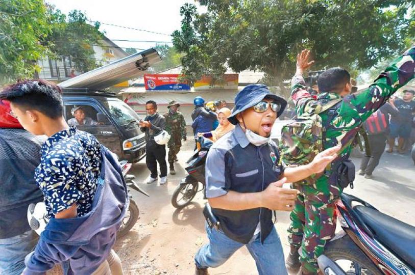 ■龍目島再強震後,士兵官員勸喻民眾冷靜。 ■龍目島再強震後,士兵官員勸喻民眾冷靜。
