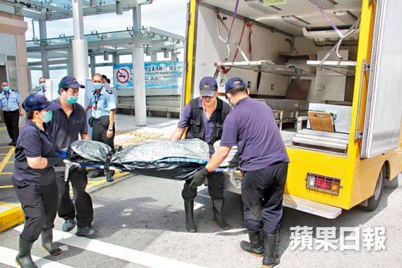 ■少女遺體由仵工移送殮房。文兆麟攝 ■少女遺體由仵工移送殮房。文兆麟攝
