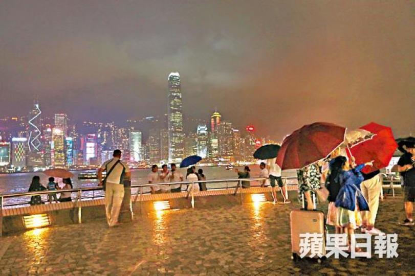 ■本港昨晚雨勢不大，在尖沙嘴海旁仍可看到港島夜景。易仰民攝