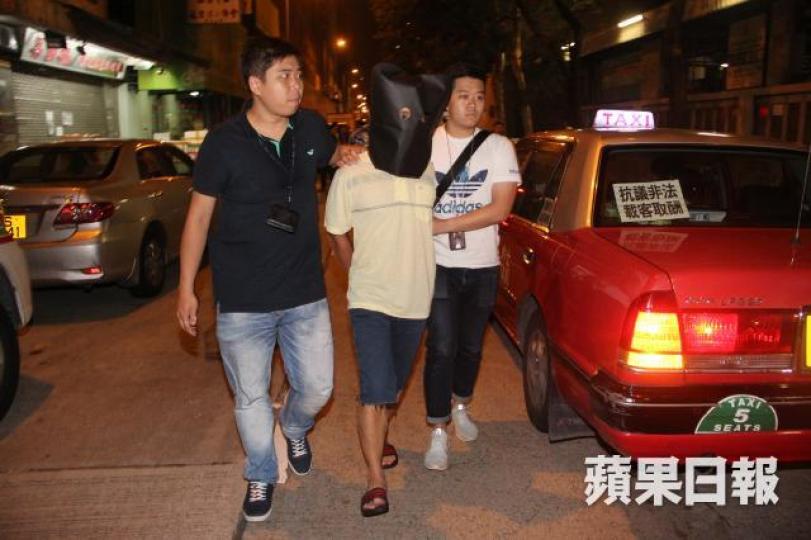 涉傷人的疑犯被黑布蒙頭帶返警署。黎志偉攝 涉傷人的疑犯被黑布蒙頭帶返警署。黎志偉攝