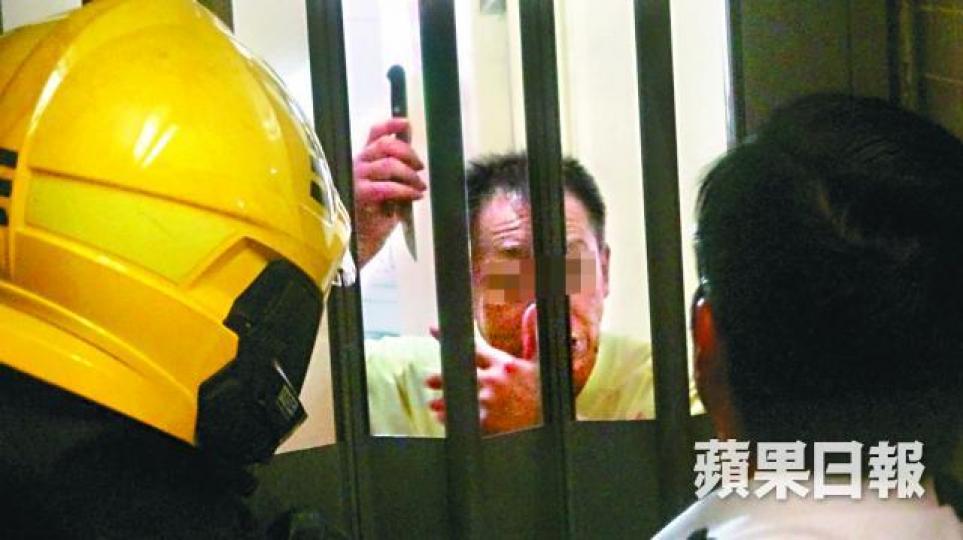 七旬翁情緒激動,手拿利刀與消防及警員對峙。詹家志攝警員穿上「鐵甲威龍」裝備,預備破門入屋。 七旬翁情緒激動,手拿利刀與消防及警員對峙。詹家志攝警員穿上「鐵甲威龍」裝備,預備破門入屋。