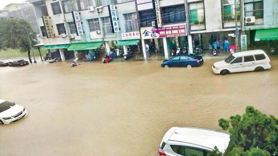暴雨淹沒鼓山一路，導致車輛被困無法前行。台灣《蘋果日報》