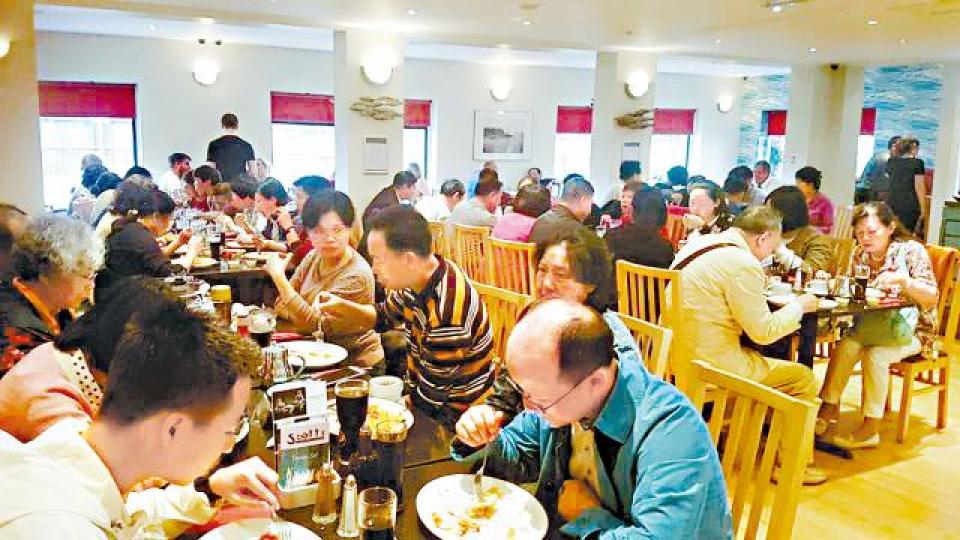 Scott's餐廳坐滿中國客。侍者捧着熱賣的炸魚薯條。 Scott's餐廳坐滿中國客。侍者捧着熱賣的炸魚薯條。