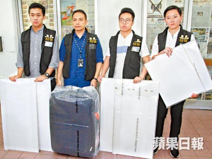 警員展示涉案的行李篋及多塊木板。 警員展示涉案的行李篋及多塊木板。