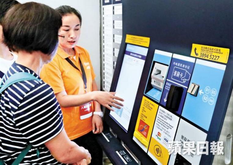 職員簡介自助售票機使用方法,但當市民嘗試自行觸碰屏幕時,職員伸手阻擋並稱暫只可由職員操作。李家皓攝西九站昨分為兩節的開放日,每節均讓5,000名持票人士進場參觀。市民進場會途經地面層,參觀B1售票大堂部份位置。不少家長帶同小朋友到場。 職員簡介自助售票機使用方法,但當市民嘗試自行觸碰屏幕時,職員伸手阻擋並稱暫只可由職員操作。李家皓攝西九站昨分為兩節的開放日,每節均讓5,000名持票人士進場參觀。市民進場會途經地面層,參觀B1售票大堂部份位置。不少家長帶同小朋友到場。