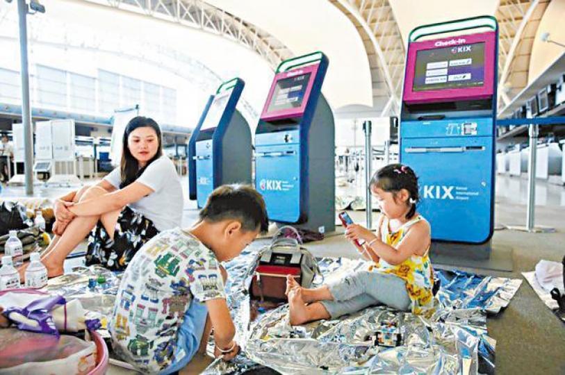 有小童被困機場,坐在地上玩手機打發時間。互聯網 有小童被困機場,坐在地上玩手機打發時間。互聯網