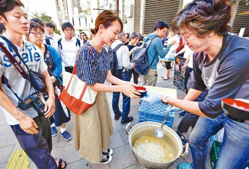【札幌】地震後僅剩零星商舖營業,有餐廳員工主動向受災市民派發食物。美聯社 【札幌】地震後僅剩零星商舖營業,有餐廳員工主動向受災市民派發食物。美聯社