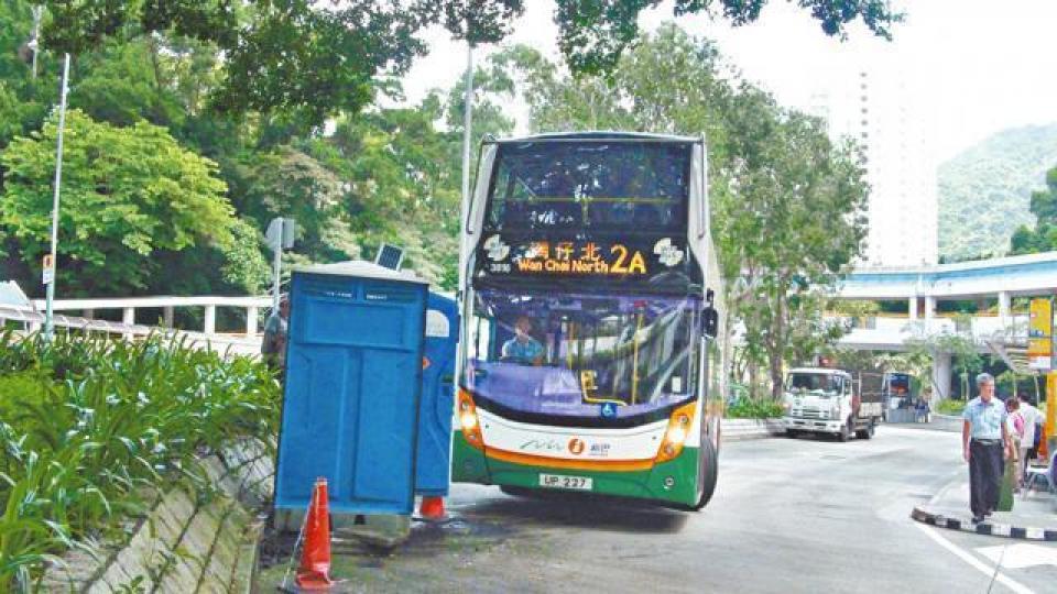 巴士行駛時與流動廁所距離極近。女車長捱撞,受傷倒地。 巴士行駛時與流動廁所距離極近。女車長捱撞,受傷倒地。