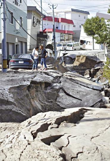 強烈地震使札幌市的路面嚴重崩裂下塌,人車難行。 美聯社 強烈地震使札幌市的路面嚴重崩裂下塌,人車難行。 美聯社
