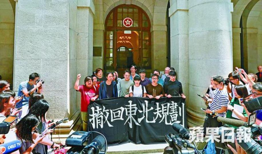 上訴得直的東北案被告昨手持「撤回東北規劃」橫額步出終院。李家皓攝 上訴得直的東北案被告昨手持「撤回東北規劃」橫額步出終院。李家皓攝