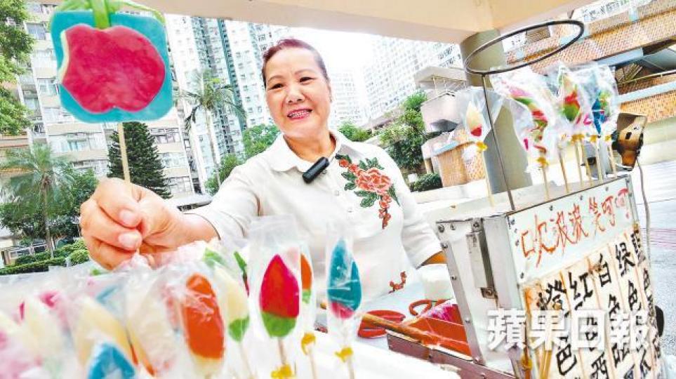 糖姨破天荒用糖膠做出《蘋果日報》的標誌。左起:高永文、高志森以及韓國女遊客都是糖姨的顧客。糖公仔造型多變,天鵝是其中之一。 糖姨破天荒用糖膠做出《蘋果日報》的標誌。左起:高永文、高志森以及韓國女遊客都是糖姨的顧客。糖公仔造型多變,天鵝是其中之一。