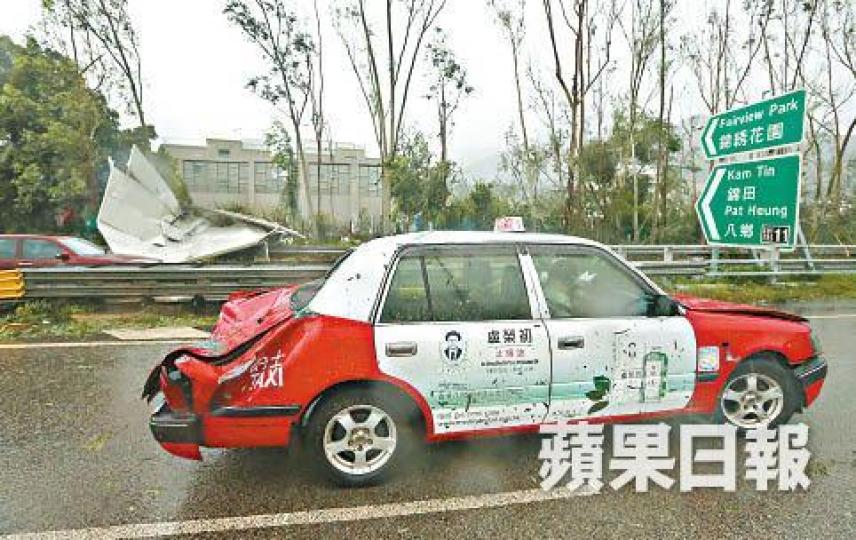 有的士被強風吹起的雜物擊中,車尾箱嚴重變形。王子俊攝 有的士被強風吹起的雜物擊中,車尾箱嚴重變形。王子俊攝