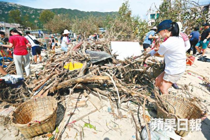 「山竹」為石澳泳灘帶來無數垃圾，昨有義工團隊到場清理。何頴賢攝與家長一同前來的小女孩也落手清理雜物。