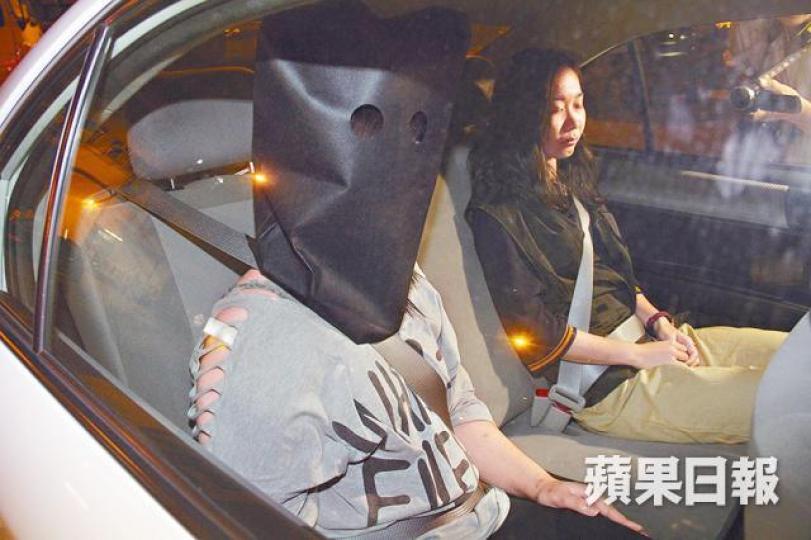 其中一名女疑犯被黑布蒙頭押返警署。黎志偉攝 其中一名女疑犯被黑布蒙頭押返警署。黎志偉攝