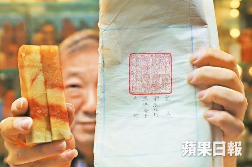 周師傅的鎮店之寶是一對非賣品太極石(左),石上的薄意出自大師林壽堪之手;而日本禪師訂造的鳥蟲文篆刻圖章(右),是周師傅的代表作之一。周師傅獲聖雅各福群會邀請任篆刻工作坊導師,與畢業學員合照。受訪者提供圖片有任職教師的日本客人幫襯周師傅後,用日文寫了一篇推介文。周啟健有5本常用的大字典,他形容啞老師越多,做出來的圖章才有變化,才會進步。篆刻可分為陽文(上排,圖中字為埃里克)及陰文(下排,圖中字為馬克)。篆刻工具包括砂紙、筆具、樞、雕刻刀等。 周師傅的鎮店之寶是一對非賣品太極石(左),石上的薄意出自大師林壽堪之手;而日本禪師訂造的鳥蟲文篆刻圖章(右),是周師傅的代表作之一。周師傅獲聖雅各福群會邀請任篆刻工作坊導師,與畢業學員合照。受訪者提供圖片有任職教師的日本客人幫襯周師傅後,用日文寫了一篇推介文。周啟健有5本常用的大字典,他形容啞老師越多,做出來的圖章才有變化,才會進步。篆刻可分為陽文(上排,圖中字為埃里克)及陰文(下排,圖中字為馬克)。篆刻工具包括砂紙、筆具、樞、雕刻刀等。