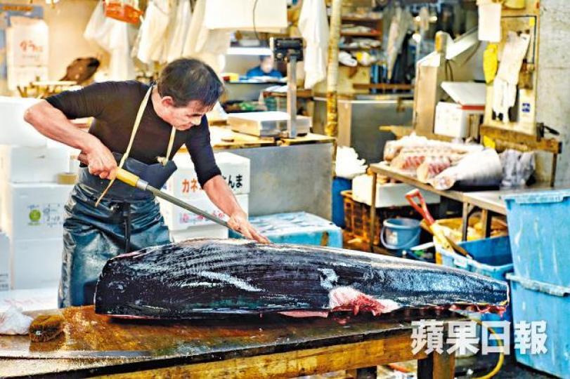 最後一天營業日,市場工人繼續為鮮魚切件。築地最後一次拍賣吸引大批傳媒採訪,記者站上矮梯拍攝。 最後一天營業日,市場工人繼續為鮮魚切件。築地最後一次拍賣吸引大批傳媒採訪,記者站上矮梯拍攝。