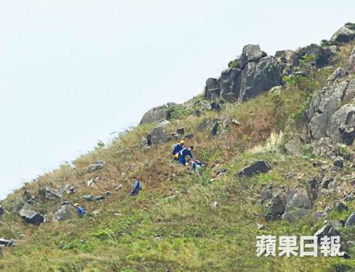 消防員接報協助兩人下山。簡明恩攝